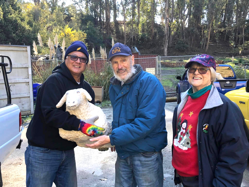 rich, jane, and marty posing for a photo with a sheep figure
